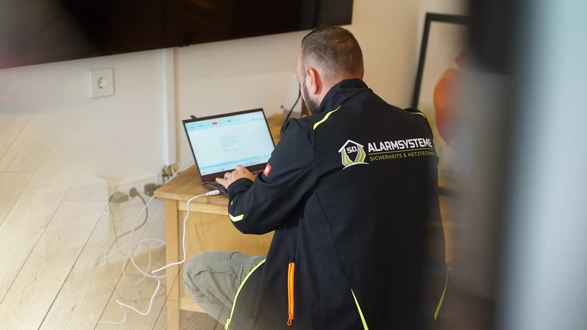 Fachkraft von SD Alarmsysteme bei der technischen Einrichtung vor Ort