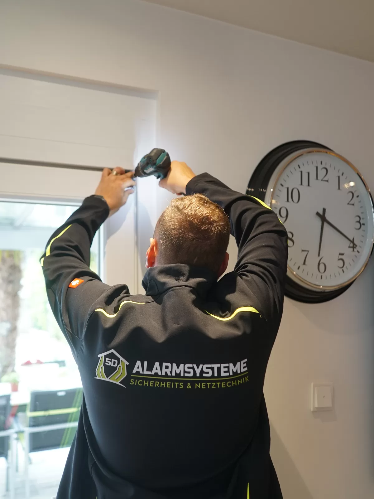 Fachkraft von SD Alarmsysteme bei einer Montage oberhalb einer Tür