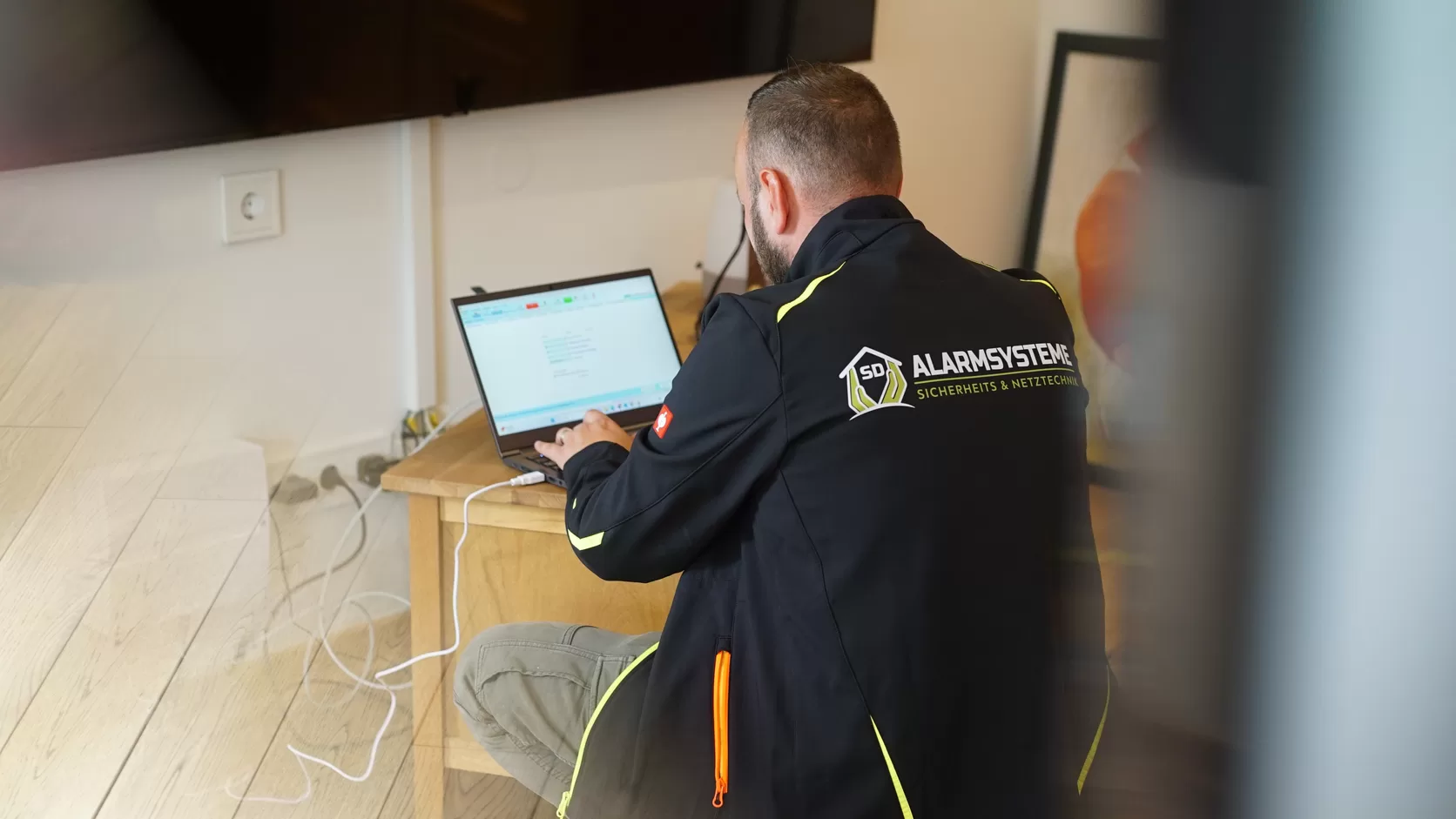 Fachkraft von SD Alarmsysteme bei der technischen Einrichtung vor Ort